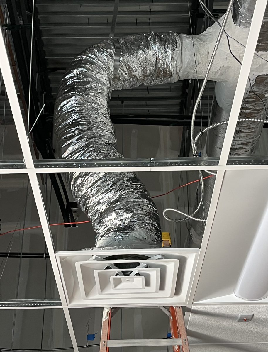 SGC Mechanical installation detail — round insulated ductwork transitioning into a finished ceiling diffuser